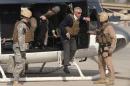 U.S. Defense Secretary Hagel wears body armor as he steps off a helicopter in Baghdad