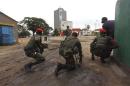 Congolese security officers position themselves as they secure the street near the state television headquarters in Kinshasa