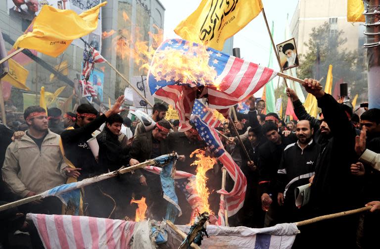 Iranians burn US flags outside the former US embassy in Tehran on November 4, 2013