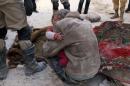 A man holds a baby in his arms following a reported air strike attack by government forces on the Hanano district of the northern Syrian city of Aleppo on February 14, 2014