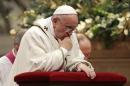 Pope Francis kneels as he leads the Christmas night mass in Saint Peter's Basilica at the Vatican