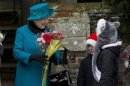 Britain's Queen Elizabeth II receives flowers from children after attending the British royal family's traditional Christmas Day church service in Sandringham, England, Tuesday, Dec. 25, 2012. (AP Photo/Matt Dunham)