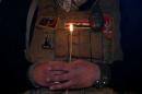 A security member holds a candle as he attends a mass on Christmas Eve at the Mar Shemoni church in the town of Bartella east of Mosul