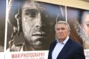 In this Thursday, Nov. 8, 2012 photo, photographer Don McCullin poses in front of the Houston Museum of Fine Arts' sign promoting the new War/Photography exhibit in Houston. The exhibit displays the work of 280 photographers from 28 nations covering the Mexican-American war in 1846 to present-day. McCullin has four photos in the exhibit. (AP Photo/Pat Sullivan)