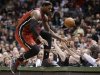 Miami Heat's LeBron James jumps onto a table while trying to save a ball going out of bounds against the Milwaukee Bucks in the second half of an NBA basketball game Friday, March, 15, 2013, in Milwaukee. (AP Photo/Jeffrey Phelps)