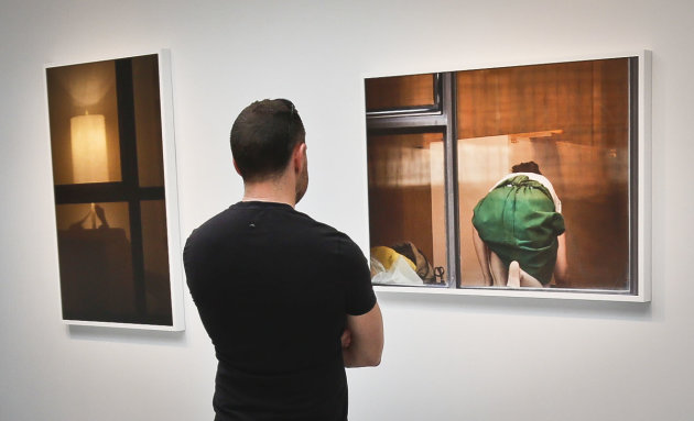 A visitor views the photography of Arne Svenson on Thursday, May 16, 2013 at the Julie Saul Gallery in New York. Residents of a New York luxury apartment building are upset over the exhibition by Svenson who secretly made their pictures from his window across the street. (AP Photo/Bebeto Matthews)