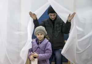 A man and child exit a voting booth after casting a&nbsp;&hellip;