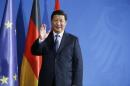 China's President Xi waves to media following joint news conference with German Chancellor Merkel at Chancellery in Berlin
