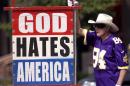 This file photo shows Fred Phelps Sr. displays one of his many infamous protest signs. Phelps, the fiery founder of the Westboro Baptist Church, a small Kansas church, who drew international condemnation for outrageous and hate-filled protests that blamed almost everything, including the deaths of AIDS victims and U.S. soldiers, on America's tolerance for gay people, has died the family said Thursday, March 20, 2014. He was 84. (AP Photo/The Topeka Capital Journal)