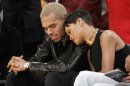 Recording artist Rihanna leans her head on Chris Brown as they sit together courtside at the NBA basketball game between the New York Knicks and Los Angeles Lakers in Los Angeles December 25, 2012. REUTERS/Danny Moloshok