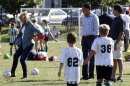 U.S. Republican presidential nominee and former Massachusetts Governor Mitt Romney and his son Tagg watch Ann Romney kick a soccer ball as they watch a children's soccer game in Belmont, Massachusetts
