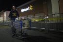 A man pushes a loaded shopping cart at a Walmart store, on Thanksgiving day in North Bergan