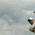 Tiger Woods of the U.S. hits from the rough during the first round of the British Open golf championship at Royal Lytham & St Annes