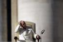 Pope Francis holds his skullcap in St. Peter's Square during his weekly general audience at the Vatican, Wednesday, Dec. 4, 2013. (AP Photo/Gregorio Borgia)