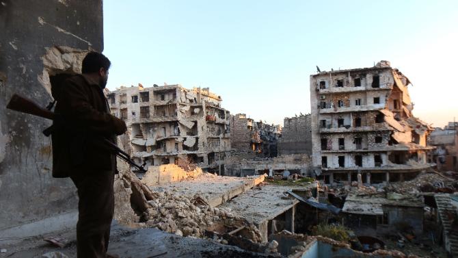 A rebel fighter stands in a building overlooking the damage from fighting in the city of Aleppo on December 16, 2013