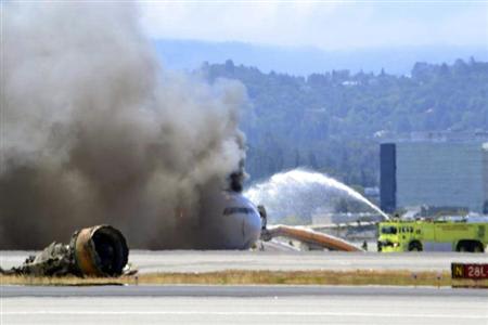 Firefighters spray water on Asiana Airlines flight 214 as it sits on the runway burning at San Francisco Airport International Airport in this July 6, 2013 handout from the United States Coast Guard Southwest.