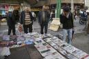 Iranians scan publications at a news stand in central Tehran, Iran, Saturday, Jan. 16, 2016. The end of Western sanctions against Iran loomed Saturday as Iran's foreign minister suggested the U.N. atomic agency is close to certifying that his country has met all commitments under its landmark nuclear deal with six world powers. (AP Photo/Vahid Salemi)