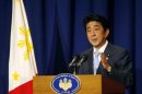 Japan's PM Abe gestures during a news conference at a hotel in Makati city, metro Manila