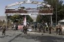 Members of the Afghan security forces stand at the site of a car bomb blast at the entrance gate to the Kabul airport
