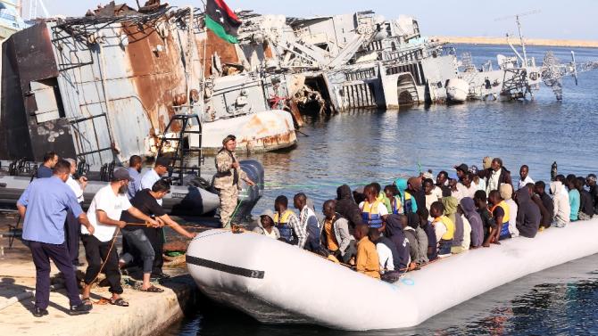 Members of the Libyan coastguard pull a boat carrying illegal African migrants, rescued as they were trying to reach Europe, at a naval base near the capital Tripoli on September 29, 2015