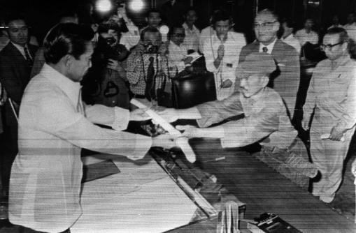 This picture taken on March 11, 1974 shows former Japanese imperial army soldier Hiroo Onoda (right) offering his military sword to former Philippine President Ferdinand Marcos to express his surrender at the Malacanan Palace in Manila