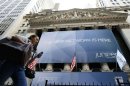 A woman walks past a banner with the logo of Juniper Networks Inc. covering the facade of the New York Stock Exchange