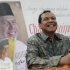 Founder and chairman CT Corp Tanjung smiles as his sits in front of his portrait at a book shop during his book launch in Jakarta