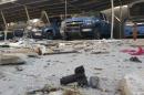 Police vehicles are parked next to debris in the Anbar province town of Hit