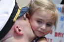 Five-year-old Adley Lausch, cries as she gets a kiss from her father, Lt., Adam Lausch, after he disembarked the nuclear powered aircraft carrier USS Harry S. Truman at Naval Station Norfolk in Norfolk, Va., Wednesday, July 13, 2016. The Truman returns after supporting missions over Iraq and Syria. (AP Photo/Steve Helber)