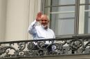 Iranian Foreign Minister Mohammad Javad Zarif waves to journalist from a balcony of the Palais Coburg where closed-door nuclear talks with Iran continue in Vienna, Austria, Monday, July 13, 2015. (AP Photo/Ronald Zak)