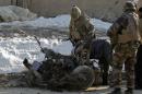 NATO troops investigate the the wreckage of a suicide bomber's car at the site of an attack in Kabul