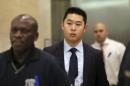 FILE - In a Tuesday, Feb. 9, 2016 file photo, Police officer Peter Liang, center, exits the courtroom during a break in closing arguments in his trial on charges in the shooting death of Akai Gurley, at Brooklyn Supreme court in New York. The manslaughter conviction against Liang, who accidentally shot the unarmed man in a public housing project stairwell will stand, a judge decided Thursday, ruling that a juror didn't intentionally withhold information during jury selection. (AP Photo/Mary Altaffer, File)