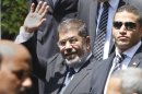 Egyptian President Mohammed Morsi waves to photographers as he leaves the Arab League headquarters in Cairo, Egypt, Wednesday, Sept. 5, 2012. Morsi says Syrian leader Bashar Assad must learn from "recent history" and step down before it is too late. (AP Photo/Amr Nabil)