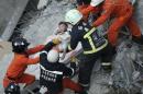 Rescue personnel help a child rescued at the site where a 17-storey apartment building collapsed during an earthquake in Tainan