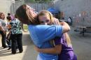 In this photo taken May 3, 2014, inmate Tiffany Dugan, left, greets her daughter, Arianne Skelton, 13, with a big hug at the Folsom Women's Facility in Folsom, Calif. Dugan had the chance to spend time with her daughter and son through a nonprofit program called Get on the Bus that arranges for children of inmates to visit their parents in California prions around Mother's and Father's days. (AP Photo/Rich Pedroncelli)