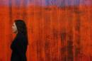 An employee poses with artist Gerhard Richter's artwork "Wand (Wall)" at Sotheby's auction house in London