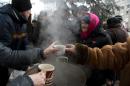 Elderly residents queue up for hot tea and biscuits at a makeshift soup kitchen on Lenin square in Debaltseve on March 2, 2015