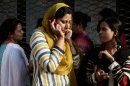 A Pakistani woman speaks on her mobile phone after rushing out of her apartment following a major earthquake that struck Baluchistan province in southwest Pakistan, 693 Kilometers (430 miles) from Karachi, Pakistan, Tuesday, Sept. 24, 2013. A deadly earthquake struck Tuesday in southwestern Pakistan sending poeople fleeing into the streets and praying for their lives as buildings swayed, officials said. (AP Photo/Shakil Adil)