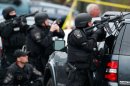 Police in tactical gear surround an apartment building in Watertown, Mass., April 19.