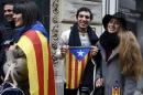 People pose with Catalan flags as they queue outside a polling station in the Delegation of the Catalan Government in France on November 9, 2014