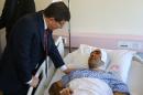 Turkish Prime Minister Ahmet Davutoglu, left, talks to a man, wounded in Wednesday's explosion in Ankara, Turkey, during a visit at the hospital, Thursday, Feb. 18, 2016. The explosion occurred during evening rush hour in the heart of Ankara, in an area close to parliament and armed forces headquarters and lodgings. (Hakan Goktepe/Prime Minister's Press Service, Pool Photo via AP)
