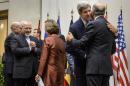 Iranian Foreign Minister Mohammad Javad Zarif (L) reacts next to EU foreign policy chief Catherine Ashton (C) as US Secretary of State John Kerry embraces French Foreign Minister Laurent Fabius (R) after a statement on November 24, 2013 in Geneva