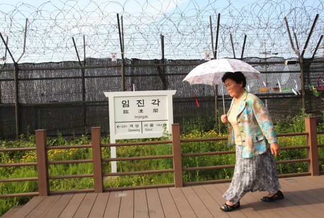 A visitor walks by a sign showing the distance to North Korea's Kaesong city and South Korea's capital Seoul at the Imjingak Pavilion near the border village of Panmunjom that has separated the two Koreas since the Korean War, in Paju, South Korea, Monday, June 10, 2013. North and South Korea agreed Monday to hold senior-level talks this week in Seoul, a breakthrough of sorts to ease tensions after Pyongyang's recent threats of nuclear war and Seoul's vows of counterstrikes. (AP Photo/Ahn Young-joon)
