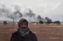 A Kurdish man stands close to the Turkish-Syrian border as smoke rises from the Syrian town of Kobane, as seen from the southeastern village of Mursitpinar, in the Sanliurfa province, on October 16, 2014