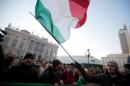 A man waves an Italian national flag during a protest against austerity measures in "Piazza Castello", in Turin on December 11, 2013