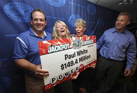 Paul White holds a check for his $149.4 million Powerball jackpot winnings at a news conference at Minnesota State Lottery headquarters in Roseville