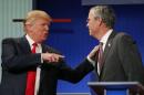 Republican 2016 U.S. presidential candidate Trump talks with fellow candidate Bush during a commercial break at the first official Republican presidential candidates debate of the 2016 U.S. presidential campaign in Cleveland