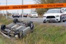 A car is overturned in the ditch in a cordoned off area in St-Jean-sur-Richelieu, Quebec on Monday Oct. 20, 2014. One of two soldiers hit by a car died of his injuries early Tuesday, according to Quebec provincial police. Provincial police say the man sped off in his car after hitting the two soldiers in the parking lot of a shopping mall, starting a chase that ended with the man losing control and his car rolling over several times. The driver died from police gunfire. The second soldier's injuries are described as less serious. (AP Photo/The Canadian Press,Pascal Marchand)