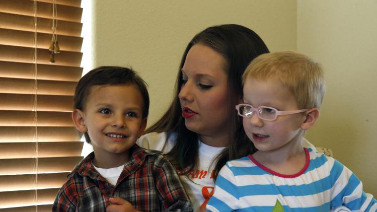 In this April 29, 2014 photo, mother of a child with cancer Sierra Riddle plays with her son Landon, age 4, left, and Landon's friend Dahlia, age 3, who also has cancer, during a play date at Dahlia's home in Colorado Springs. Landon and Dahlia's parents, frustrated with mainstream medical treatments and facing the possibility of intervention by child protective authorities, moved to Colorado to treat their children using what some describe as cutting edge cannabis medication. Hundreds of parents in similar situations find themselves at the center of a debate about how far government can and should reach when parents push against legal boundaries to save their childrens' lives. (AP Photo/Brennan Linsley)