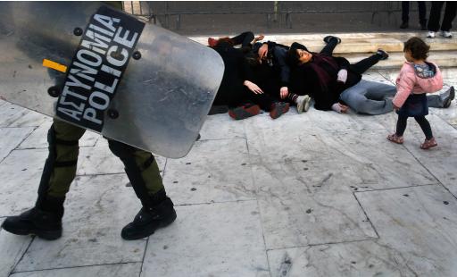 Protesters lie in front of the parliament during march in Athens